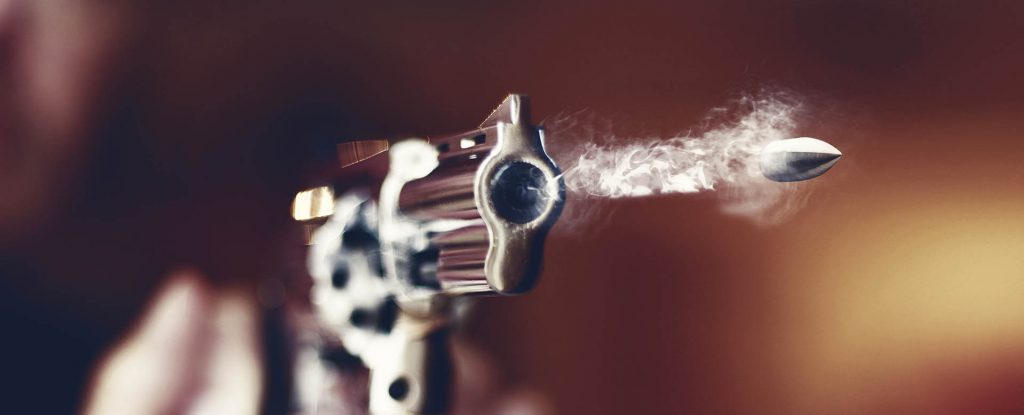 a bullet being fired from a revolver