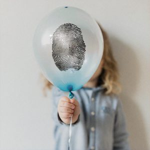 Child,Holding,Balloon,With,Fingerprint,Pattern,Enlarged,On,It